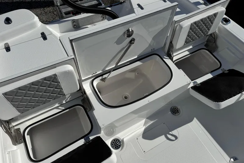 Slide: The Image of 2026 BlackJack 256 Bay boat storage compartments with open lids, showcasing interior design. - 18