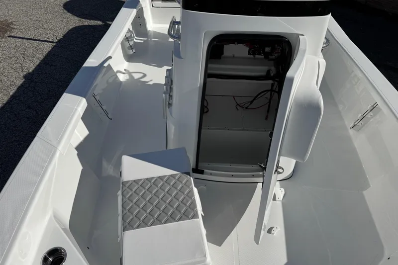 Slide: The Image of 2026 BlackJack 256 Bay boat interior with open storage compartment and cushioned seating. - 20