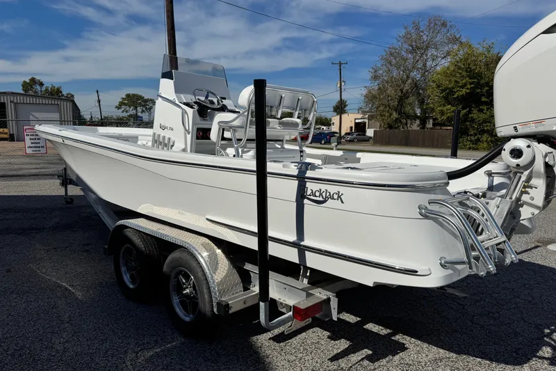 Slide: The Image of 2026 BlackJack 256 Bay boat on trailer, parked outdoors under clear sky. - 5