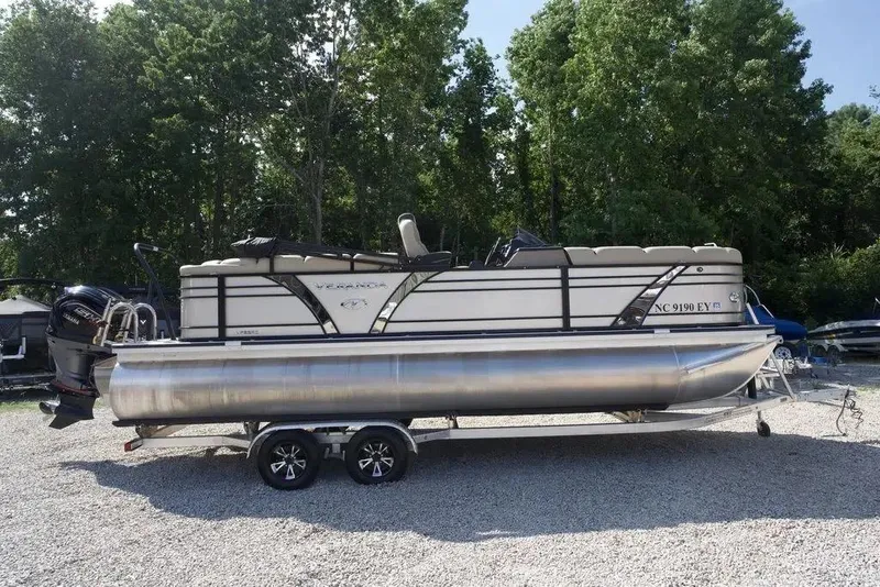The Image of 2023 Veranda VP 22RC pontoon boat on trailer, parked on gravel with trees in background. - 1