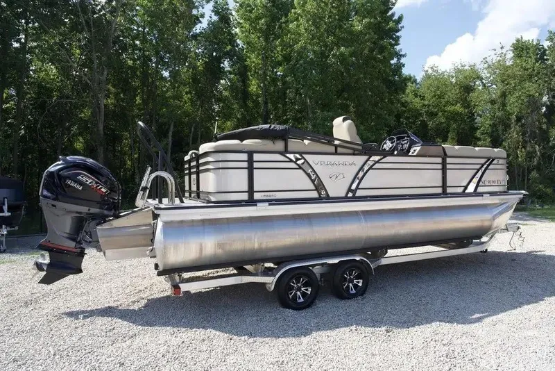 Slide: The Image of 2023 Veranda VP 22RC pontoon boat with Yamaha engine, parked on gravel, surrounded by trees. - 18