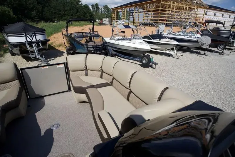 Slide: The Image of 2023 Veranda VP 22RC pontoon boat with beige seating, parked among other boats. - 6