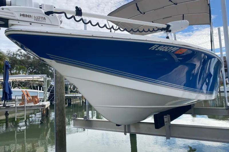 Slide: The Image of 2004 Palmetto 22 Excursion boat with blue hull on a lift, featuring Minn Kota Terrova motor. - 10