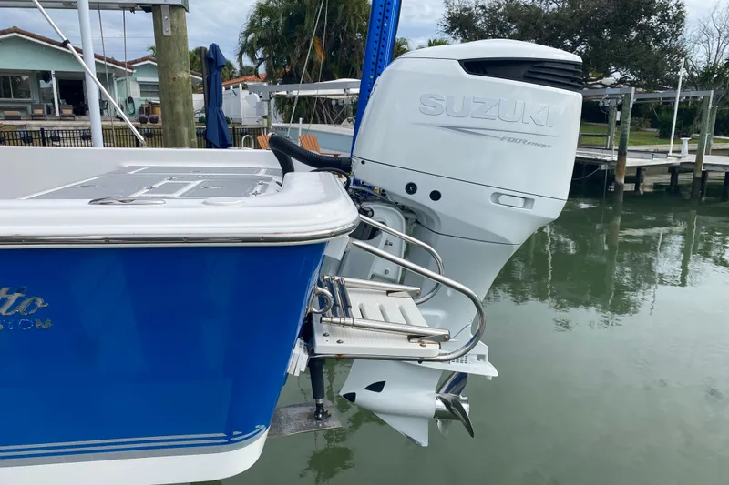 Slide: The Image of 2004 Palmetto 22 Excursion boat with Suzuki outboard motor, docked by waterfront. - 14