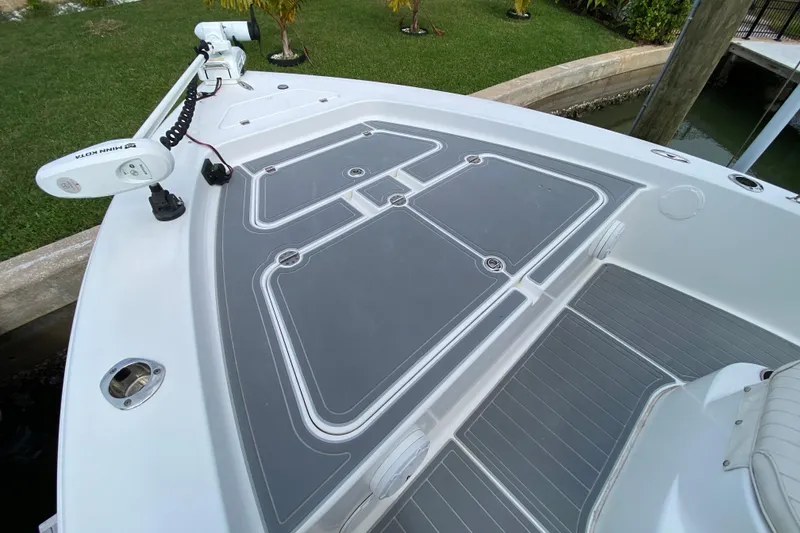 Slide: The Image of 2004 Palmetto 22 Excursion boat deck with Minn Kota trolling motor, docked near grassy area. - 16