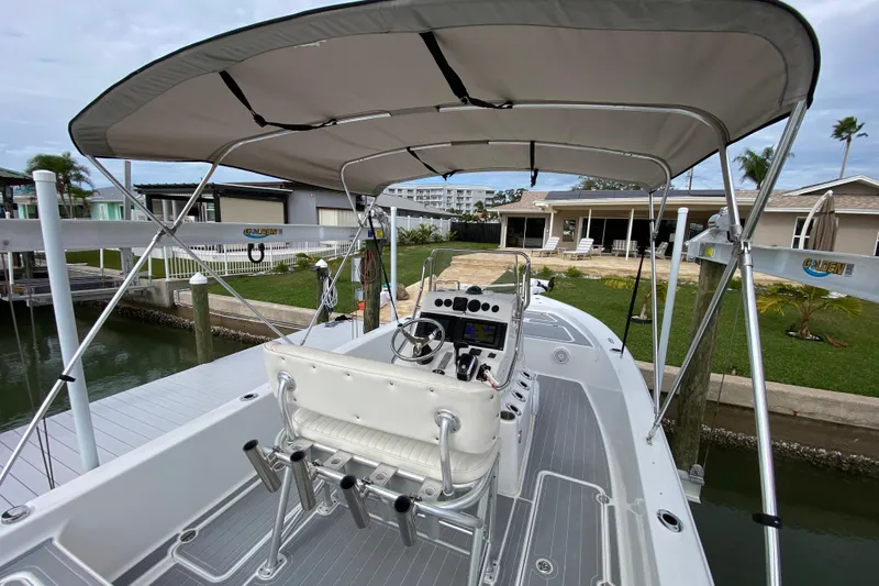 Slide: The Image of 2004 Palmetto 22 Excursion boat docked, featuring a spacious deck and canopy. - 47