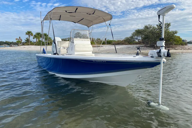 Slide: The Image of 2004 Palmetto 22 Excursion boat docked near sandy beach with clear skies. - 5