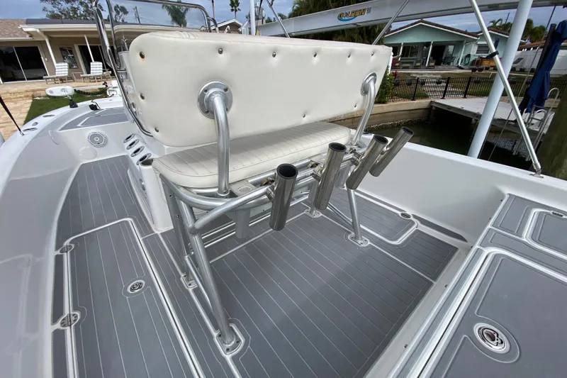 Slide: The Image of 2004 Palmetto 22 Excursion boat with white seating and rod holders on a gray deck. - 56