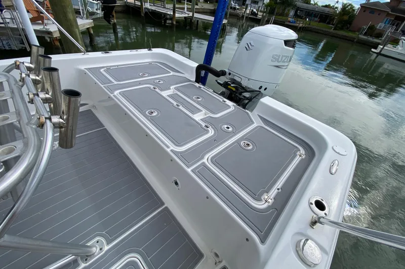 Slide: The Image of 2004 Palmetto 22 Excursion boat with Suzuki outboard motor, docked by the water. - 59