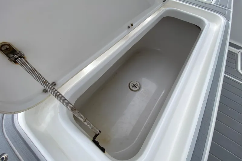 Slide: The Image of Open storage compartment on 2004 Palmetto 22 Excursion boat, featuring a drain plug. - 67
