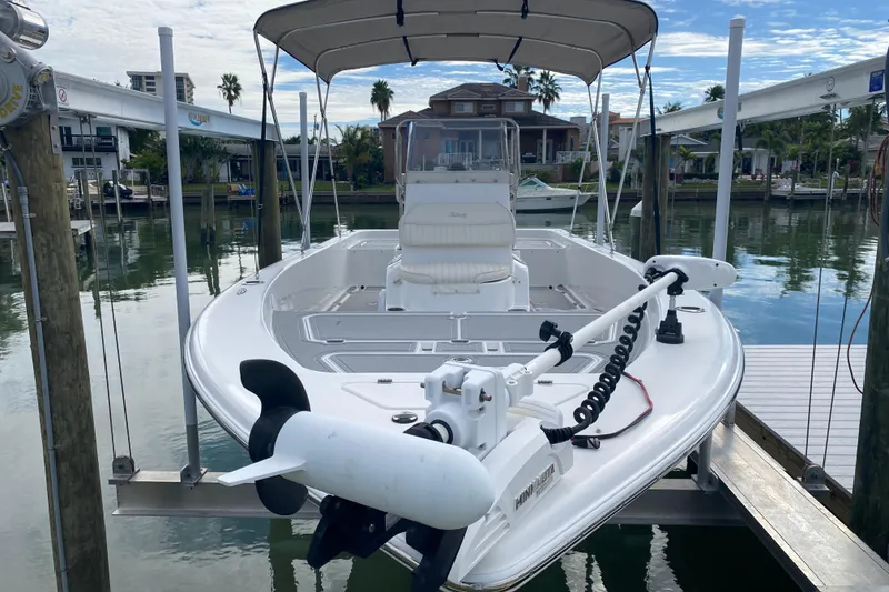 Slide: The Image of 2004 Palmetto 22 Excursion boat docked, featuring a trolling motor and canopy. - 9