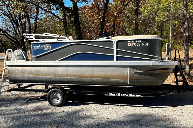 Slide: The Image of 2017 SunCatcher V18 Cruise pontoon boat on trailer, parked outdoors. - 1