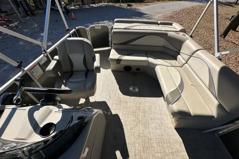 Slide: The Image of 2017 SunCatcher V18 Cruise pontoon boat interior with beige seating and steering console. - 14