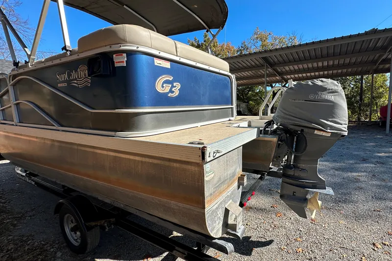 Slide: The Image of 2017 SunCatcher V18 Cruise pontoon boat with Yamaha outboard motor, parked under a canopy. - 5