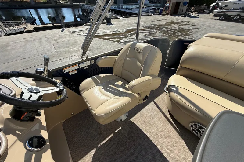 Slide: The Image of 2017 Manitou 230 boat interior with beige seating and steering wheel. - 15