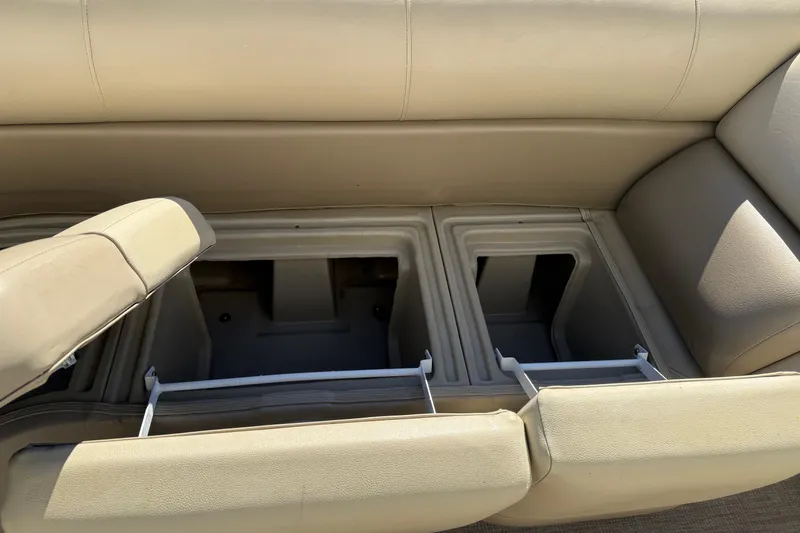 Slide: The Image of 2017 Manitou 230 boat storage compartments with beige seating. - 18