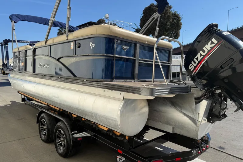 Slide: The Image of 2017 Manitou 230 pontoon boat with Suzuki outboard motor on trailer. - 4