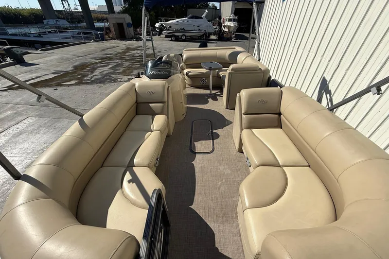 Slide: The Image of 2017 Manitou 230 pontoon boat with beige seating and spacious deck layout. - 8