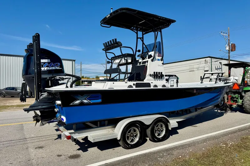 Slide: The Image of 2018 Shallow Sport 25 X3 boat on trailer, featuring Yamaha engine, parked outdoors. - 4