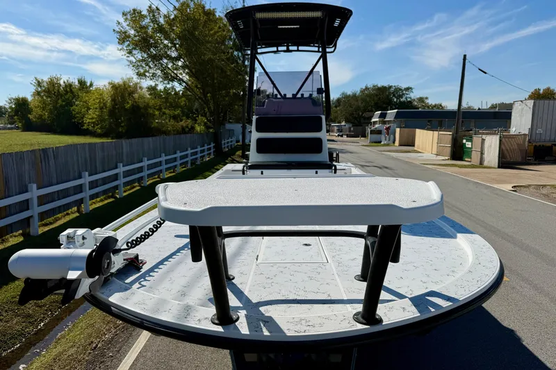 Slide: The Image of 2018 Shallow Sport 25 X3 boat on road, showcasing deck and trolling motor. - 6