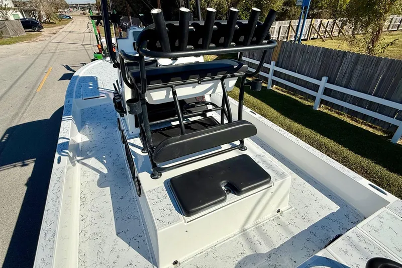 Slide: The Image of 2018 Shallow Sport 25 X3 boat with rod holders and seating, parked on a street. - 8