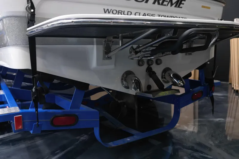 Slide: The Image of Rear view of 2012 Supreme V226 boat on blue trailer, showcasing exhaust and tow features. - 13