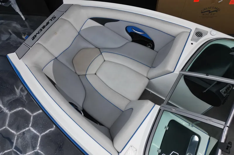 Slide: The Image of Interior of a 2012 Supreme V226 boat with gray seating and blue accents. - 5
