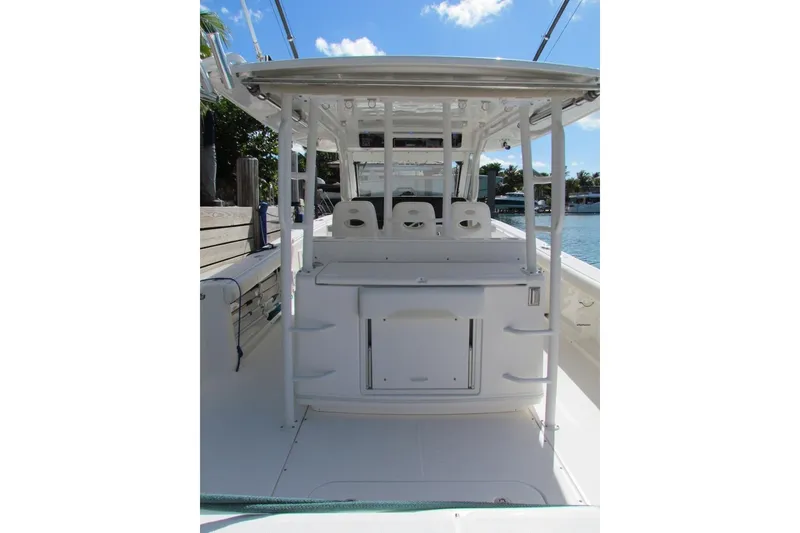 Slide: The Image of 2016 Everglades 435 Center Console boat interior with seating and storage, docked by water. - 11
