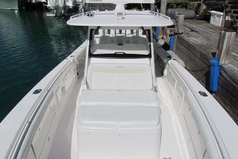 Slide: The Image of 2016 Everglades 435 Center Console boat docked, showcasing sleek design and spacious seating. - 15