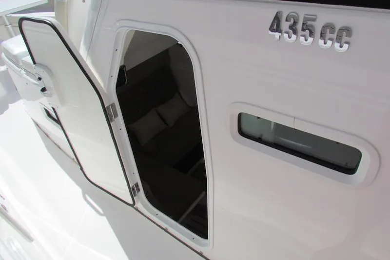 Slide: The Image of 2016 Everglades 435 Center Console cabin entrance with open door and visible interior. - 21
