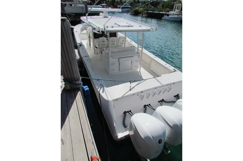 Slide: The Image of 2016 Everglades 435 Center Console boat docked, featuring triple outboard engines. - 24