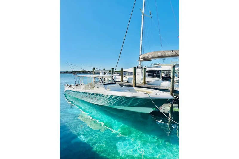 Slide: The Image of 2016 Everglades 435 Center Console boat docked in clear turquoise water. - 3