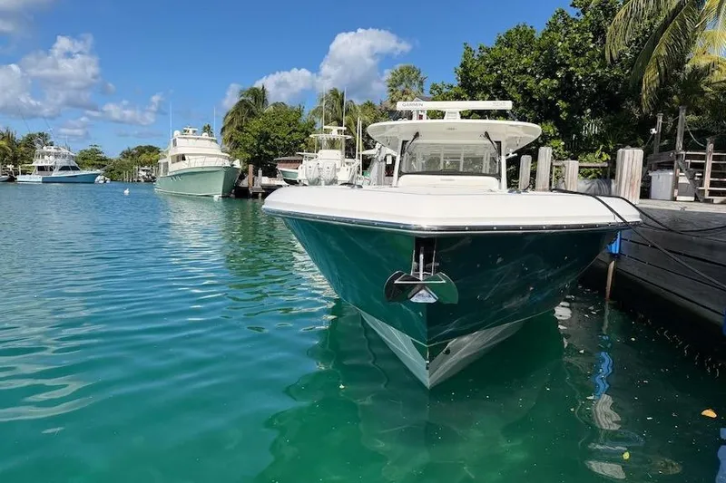 Slide: The Image of 2016 Everglades 435 Center Console boat docked in clear blue water. - 4