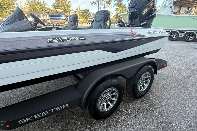 Slide: The Image of 2026 Skeeter ZXR21 SE boat on trailer, showcasing sleek design and dual wheels. - 3