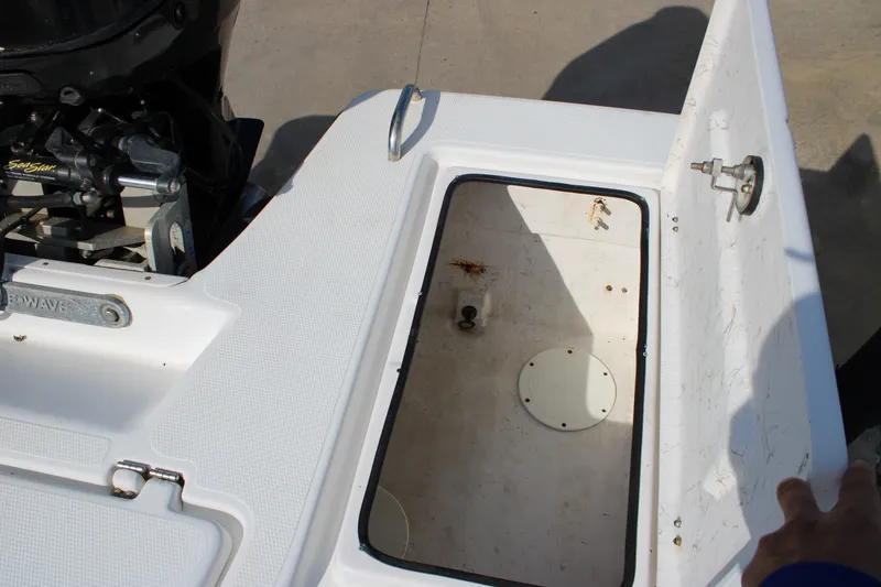 Slide: The Image of 2011 Blue Wave 2200 STL boat storage compartment with open hatch and visible engine components. - 17