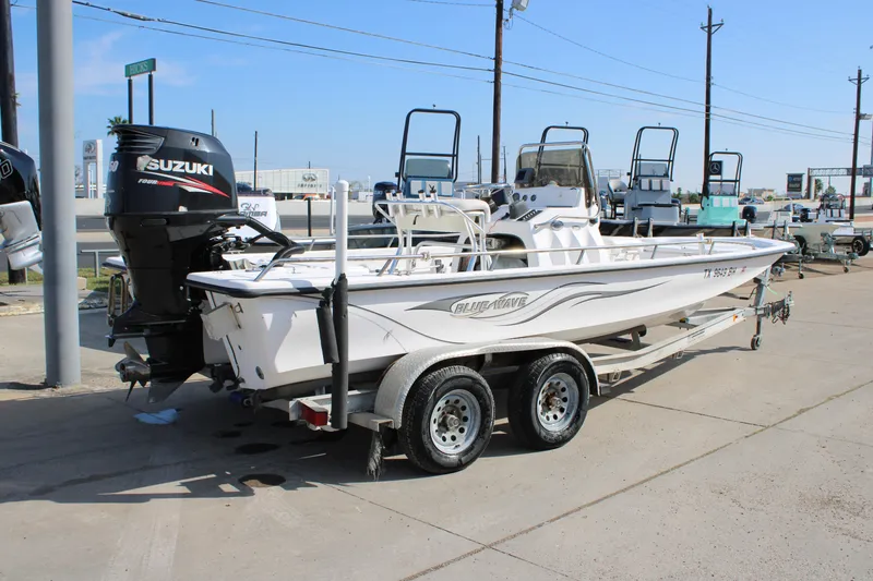 Slide: The Image of 2011 Blue Wave 2200 STL boat on trailer with Suzuki outboard motor. - 2