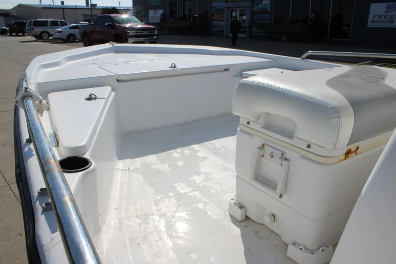 Slide: The Image of 2011 Blue Wave 2200 STL boat interior with seating and storage, parked outdoors. - 6
