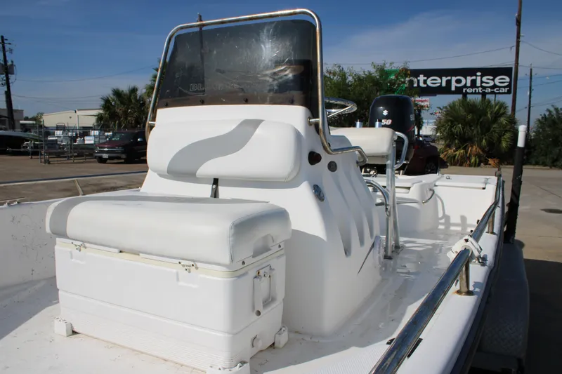 Slide: The Image of 2011 Blue Wave 2200 STL boat with white seating and console, parked outdoors. - 7