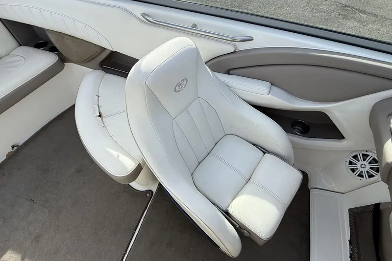 Slide: The Image of 2004 Cobalt 250 boat interior with white seating and speaker. - 16