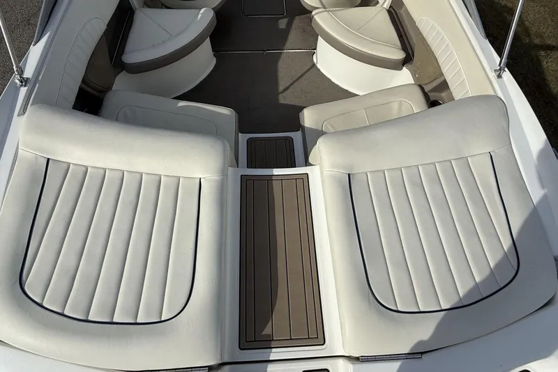 Slide: The Image of 2004 Cobalt 250 boat interior with white cushioned seating and wood accents. - 21