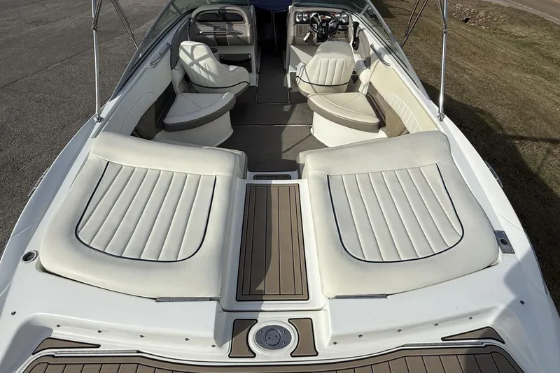 Slide: The Image of 2004 Cobalt 250 boat interior with white seating and wood accents. - 22
