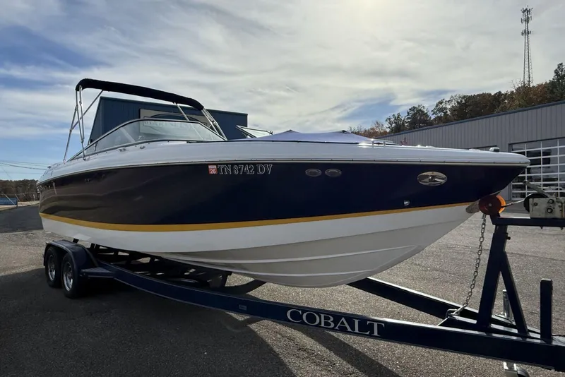 Slide: The Image of 2004 Cobalt 250 boat on trailer, blue and white design, parked outdoors. - 8