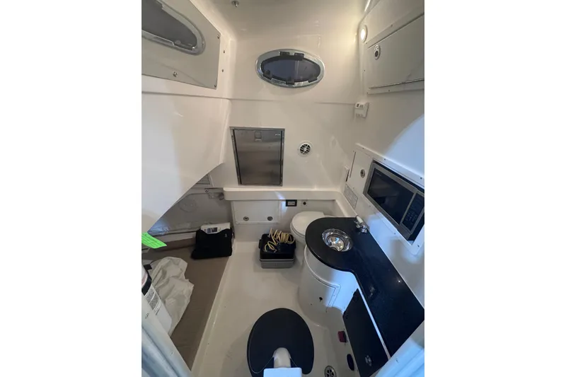 Slide: The Image of Interior of a 2010 Regulator 34SS boat, featuring a compact, well-equipped cabin. - 15