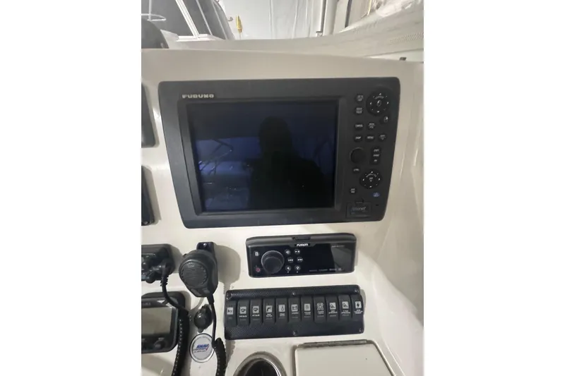 Slide: The Image of Control panel of a 2010 Regulator 34SS boat featuring navigation and communication equipment. - 28