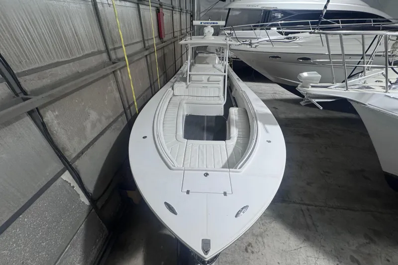 Slide: The Image of 2010 Regulator 34SS boat in storage, featuring sleek white design and spacious seating. - 34