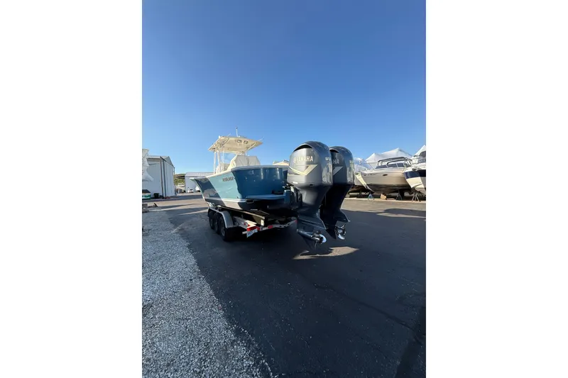 Slide: The Image of 2010 Regulator 34SS boat with dual Yamaha engines on a trailer, parked outdoors. - 6