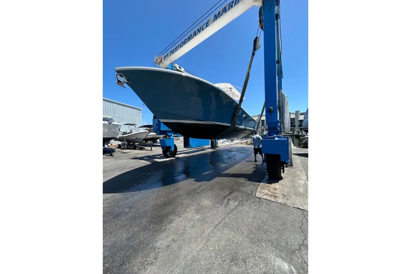 Slide: The Image of 2010 Regulator 34SS boat lifted at marina under clear blue sky. - 8