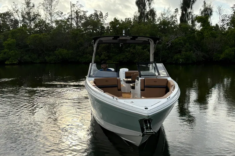 Slide: The Image of 2026 Cobalt R8 Outboard boat on calm water, surrounded by lush greenery. - 1