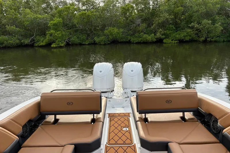 Slide: The Image of 2026 Cobalt R8 Outboard boat with dual engines, brown seating, and scenic water backdrop. - 15