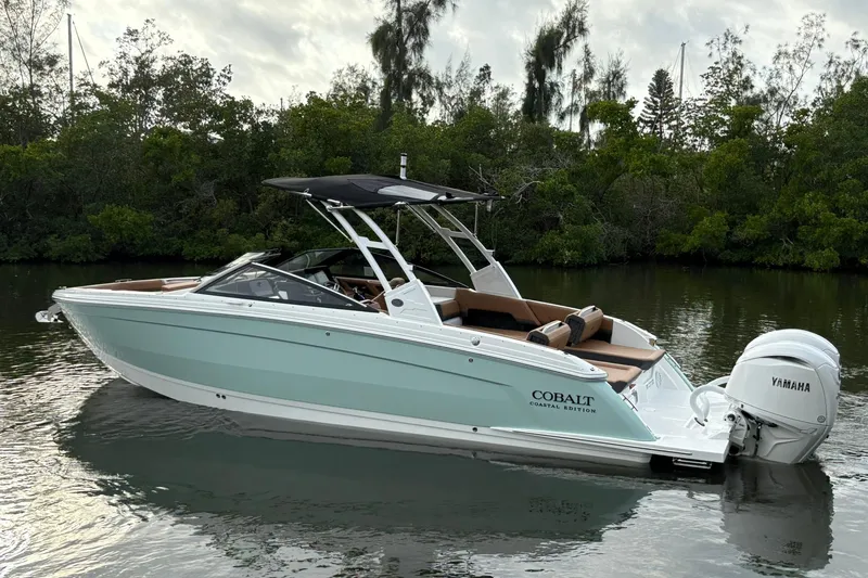 Slide: The Image of 2026 Cobalt R8 Outboard boat on calm water, surrounded by lush greenery. - 3